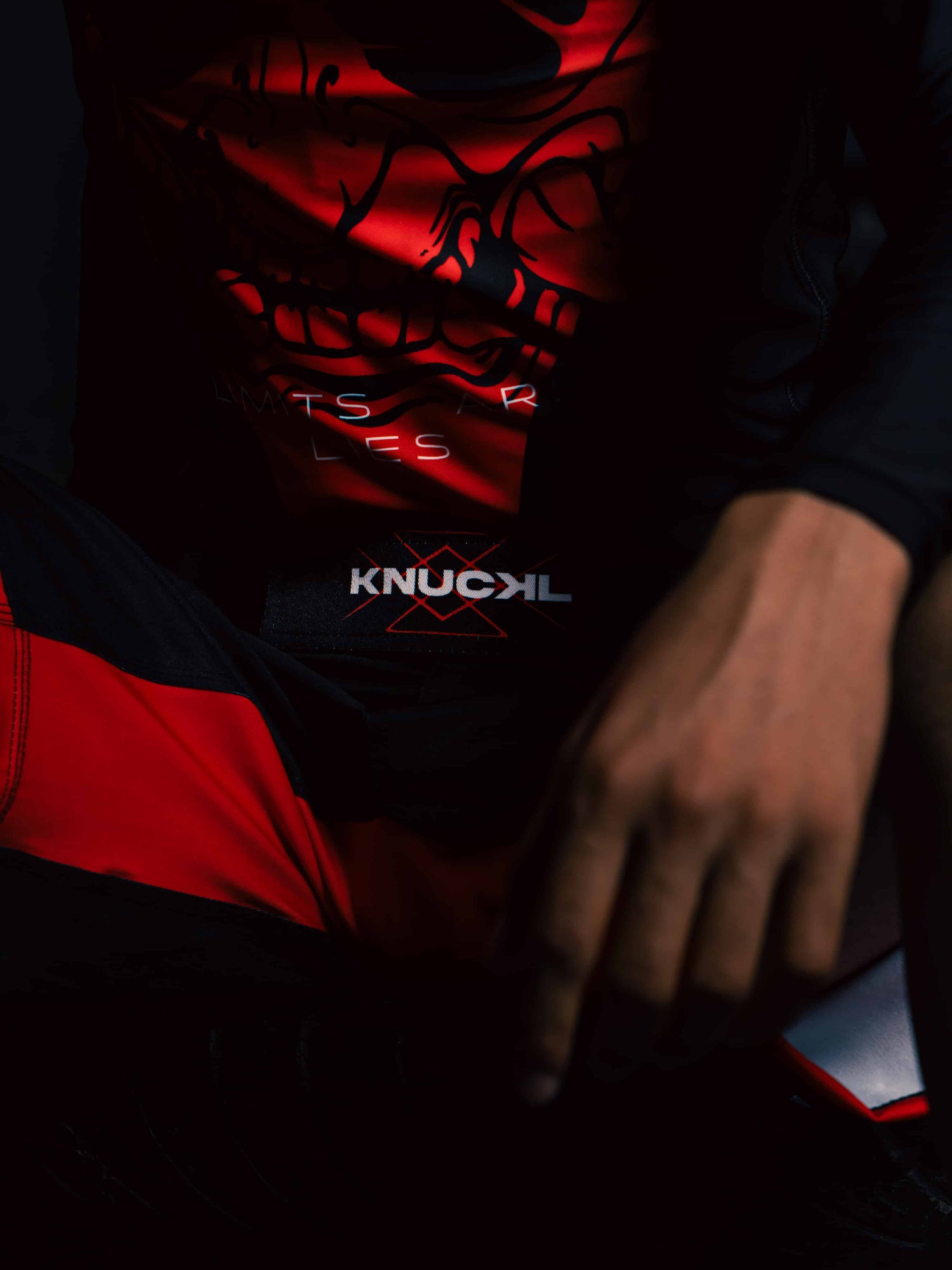 Fighter wearing Knuckl rash guard and shorts, seated in pre-fight pose