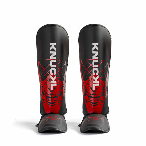 Knuckl Oni shin guards front view with red mask graphic