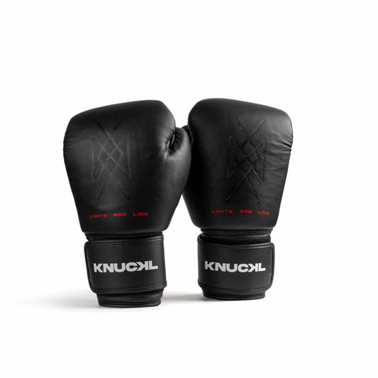 Black leather boxing gloves front view with Knuckl logo and red LIMITS ARE LIES text