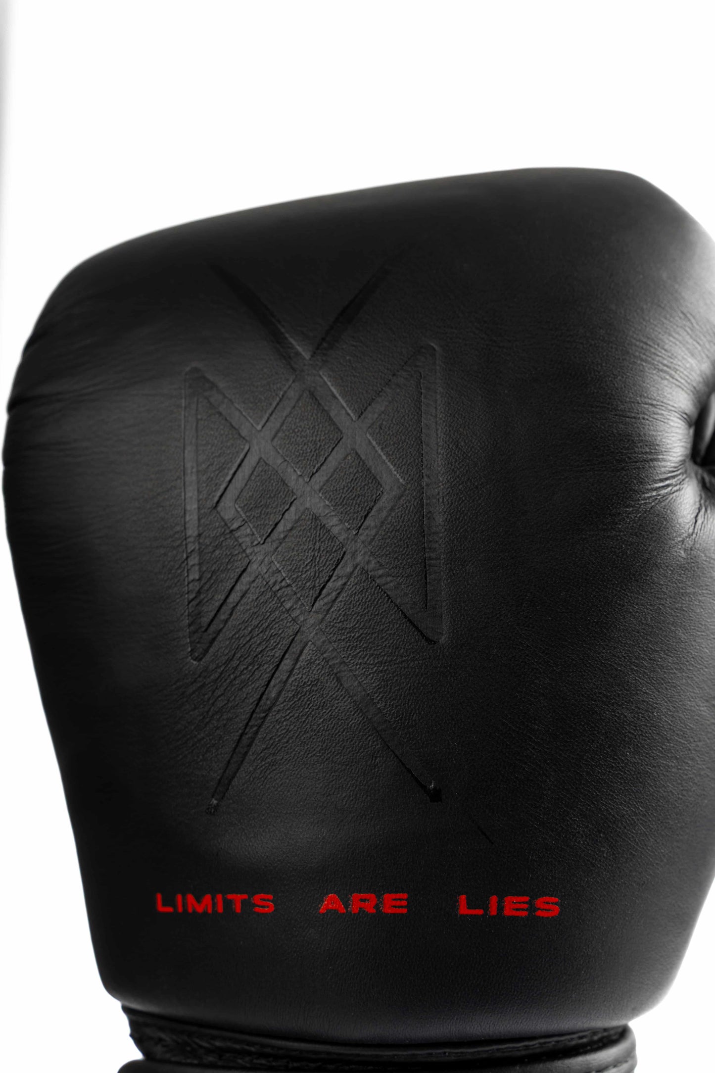 Close-up of warrior symbol embossed on leather glove with LIMITS ARE LIES