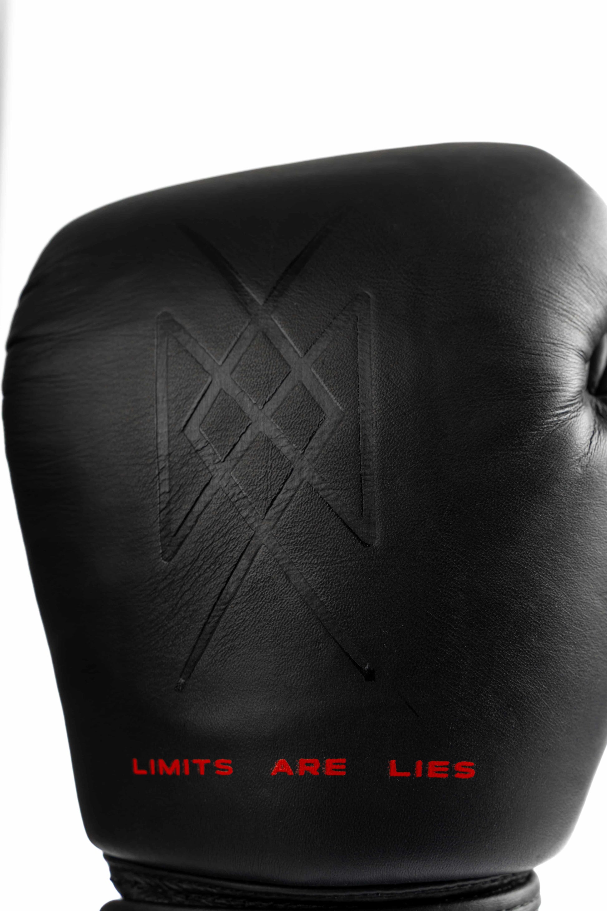 Close-up of warrior symbol embossed on leather glove with LIMITS ARE LIES
